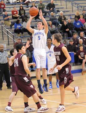 Brandan Warner (5) goes up for a shot over Benton's Sloan Paul (24) and Blake Patterson (10) as teammate K.J. Hill (4) looks on. (Photo by Kevin Nagle)