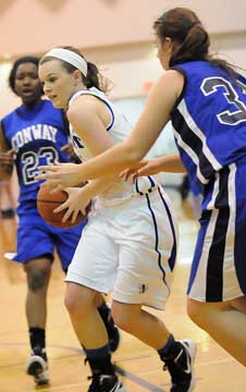 Bryant's Logan Davis drives between a pair of Conway defenders Clair Hobbs, 23, and Emilee Sanders. (Photo by Kevin Nagle)