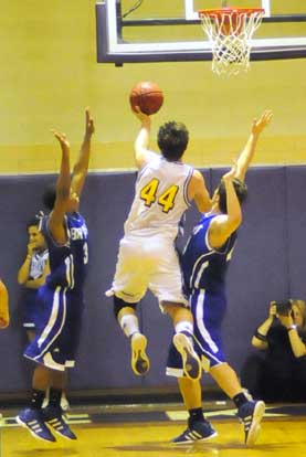 Catholic's Matt Morris (44) goes up for a shot between Bryant's Zach Cambron and C.J. Rainey. (Photo by Kevin Nagle)