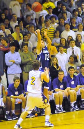 Brantley Cozart (12) launches a 3-pointer over Catholic's Mitchell Luther. (Photo by Kevin Nagle)