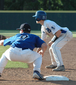 Trevor Ezell leads off first as Conway's Reid Blaylock (9) holds him. (Photo by Kevin Nagle)