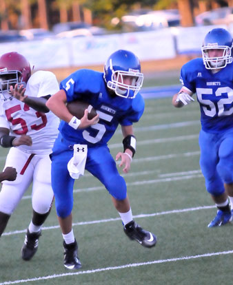 Gunnar Burks (5) heads upfield with Peyton Robertson (52) tries to get in position for a block. (Photo by Kevin Nagle)