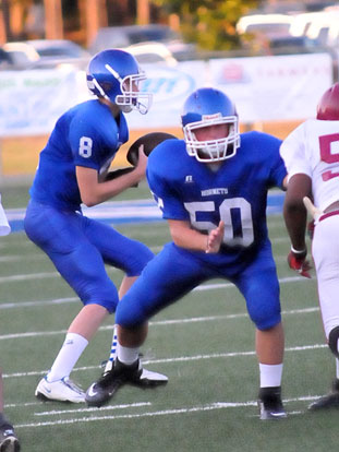 Jaret Jacobs (8) takes a snap as Austin Fason (50) sets up in protection. (Photo by Kevin Nagle)