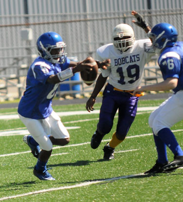 Desmond Duckworth (8) escapes Dunbar's Terrell Humphrey (19) with help from teammate Zach Norton (76). (Photo by Kevin Nagle)