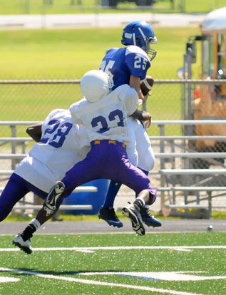 Jeffrey Hastings (25) goes up for a reception as he's hit by Dunbar's Alex Day (28) and Xavier Jones (33). (Photo by Kevin Nagle)