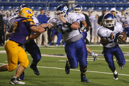Jalen Bell (20) tries to turn the corner with teammate Blake Hobby (73) leading the way. (Photo by Rick Nation)
