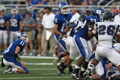 Josh Lowery (15) watches his kick head toward the uprights out of the hold of Austin Vail (11). (Photo by Rick Nation)