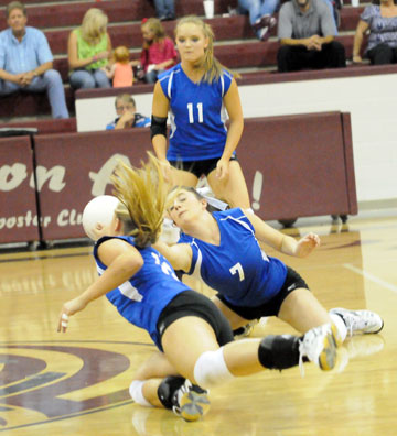 Courtney Davidson (7) and McKenzie Rice dive for a dig in front of teammate Hannah Rice (11). (Photo by Kevin Nagle)