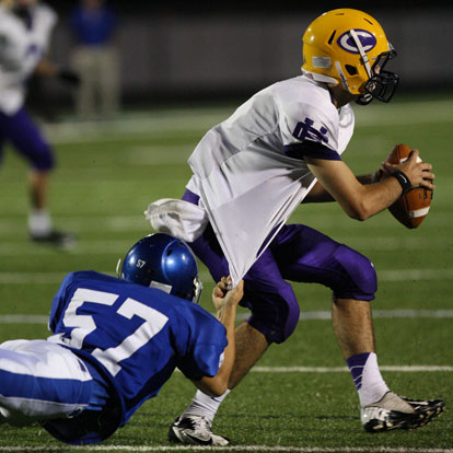 Bryant's Nick Gatlin (57) hangs on to Catholic quarterback Andre Sale. (Photo by Rick Nation)