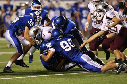 Justin Hollingshead (90), Tyree Reese (33) and Jake Johnson (35) help haul down Terek Beaugard. (Photo by Rick Nation)