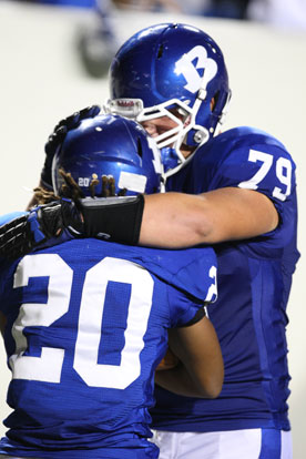 Tackle Jordan Jones (79) hugs teammate Jalen Bell (20) after one of Bell's two touchdowns against Benton last Friday. (Photo by Rick Nation)