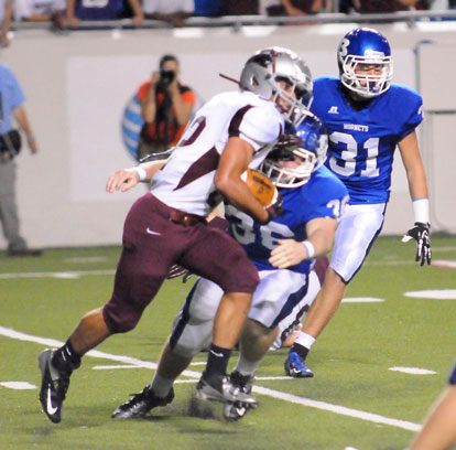 Austin May (36) hits Benton quarterback Terek Beaugard as Bryant's Stoney Stevens (31) closes in. (Photo by Kevin Nagle)