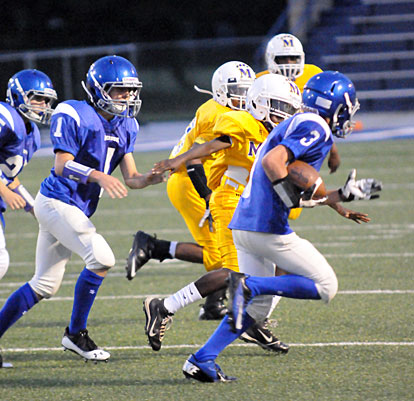 Sam Harrison (3) tries to get outside with help from teammates Chase Kincaid (1) and Jeffery Hastings. (Photo by Kevin Nagle) 