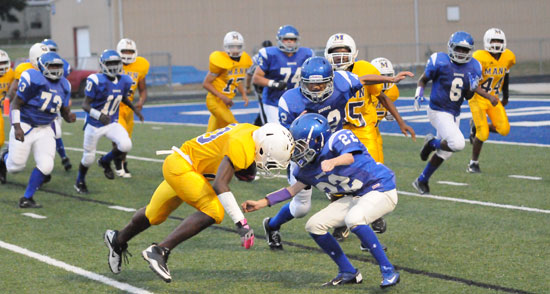 Zack Lewis (22) makes a tackle as teammates, from left, D.J. Buckner, Caylin Allen, London Taylor, Dillon Medlock and Phillip Isom-Green converge. (Photo by Kevin Nagle)