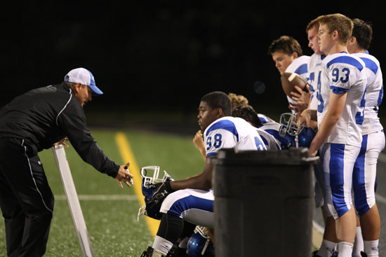 Offensive line coach Kirk Bock instructs Cameron Murray (98), Ethan Burnett (93) and the rest of the linemen while the Hornets were on defense Thursday night. (Photo by Rick Nation)