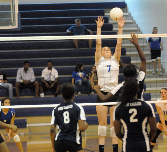 Courtney Davidson (7) goes high to make a block. (Photo by Kevin Nagle)