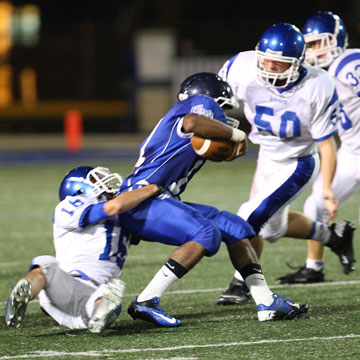 Nick Hardin (16) hauls down Conway's Cris Cotton as help arrives from Austin Fason. (Photo by Rick Nation)