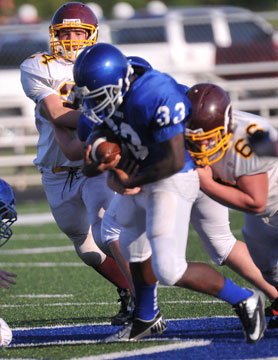 Cameron Coleman (33) fights for yardage. (Photo by Kevin Nagle)