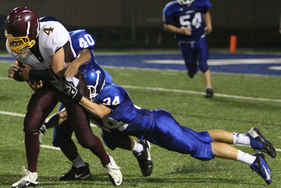 Lake Hamilton's Gip Burrow (4) is dragged down by Bryant's Kameron Guillory (40) and Devon Alpe (34). (Photo by Rick Nation)