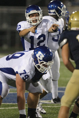 Bryant quarterback Brandan Warner (12) points out potential blitzers as Jordan Jones (79) sets up on the offensive line. (Photo by Rick Nation)