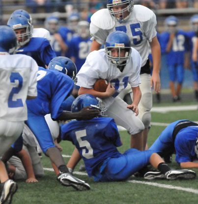 Bryant Blue's Wyatt Hoyt (5) latches onto a Bryant White running back. (Photo by Kevin Nagle)