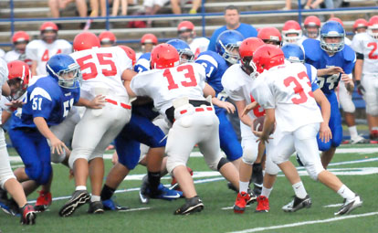 Bryant Blue defenders Logan Rich (51), Brandon Hoover (61) and Cole Campbell (54) and their teammates try to get some penetration against the Cabot North offensive line as quarterback Rail Gilliam hands to Noah Sorrell (33). (Photo by Kevin Nagle)