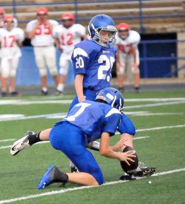 Luke Welch boots an extra point out of the hold of Cameron Vail. (Photo by Kevin Nagle)