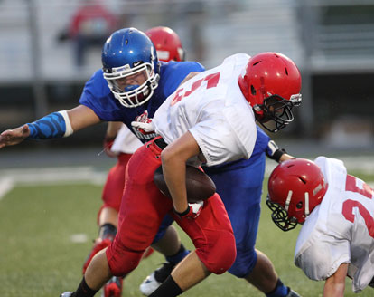 Bryant's London Taylor overcomes the holding of Cabot's Landon Teer (25) to grab running back Kaleb Schmidt. (Photo by Rick Nation)