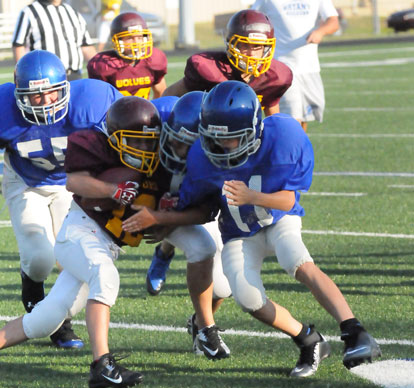 A pair of Bryant White players including Coby Greiner (11) stop a Lake Hamilton ball carrier. (Photo by Kevin Nagle)