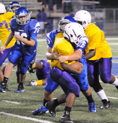 Ryan Harris (75) wraps up a Dunbar ball carrier as Joe Wyllia (76) moves in to help out. (Photo by Kevin Nagle)