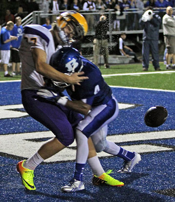 Bryant's Mark Nelson drills Catholic punter Josh Hartnedy, knocking the ball loose in the end zone. (Photo by Rick Nation)