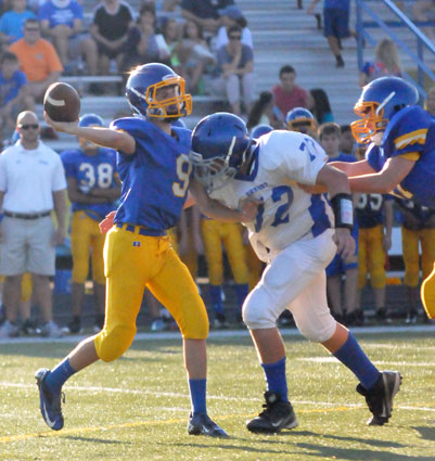 Bryce Thomas (72) pressures Lakeside quarterback Adam Saveall (9) despite being held. (Photo by Kevin Nagle)