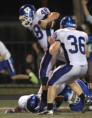 Connor Chapdelaine (48) returns a fumble recovery as teammate Austin May (36) tries to help his progress. (Photo by Rick Nation)