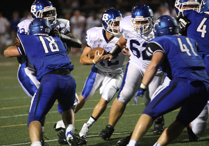 Quarterback Brandan Warner turns upfield off blocks by Demaja Price, left, and Josh Earls (62). (Photo by Rick Nation)