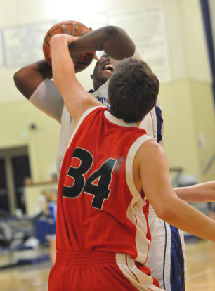 Bryant's Cameron Murray gets hacked as he tries to go up for a shot over Cabot North's Chandler Casteel. (Photo by Kevin Nagle)