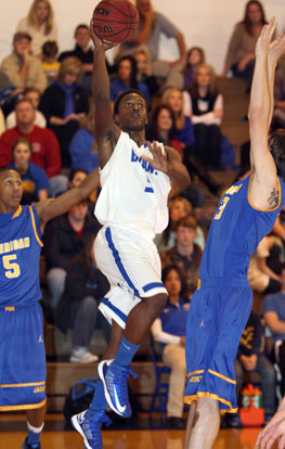 K.J. Hill fires up a shot over a pair of Sheridan defenders. (Photo by Rick Nation)