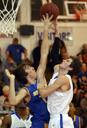 Bryant's Luke Rayburn is challenged on his shot by Sheridan's Damon Padgett. (Photo by Rick Nation)