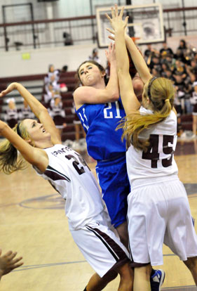 Courtney Davidson (21) is fouled on a drive to the basket as Benton's Baylee Landreth (45) and Madi Brooks (24) defend. (Photo by Kevin Nagle)