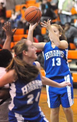 Kara Moser (13) launches a shot as teammate Britney Sahlmann rolls around a Malvern defender to get into rebounding position. (Photo by Kevin Nagle)