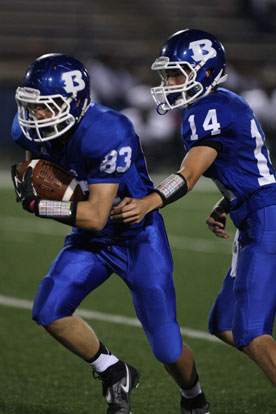 Madison Schroeder (14) hands off to Jordan Gentry. (Photo by Rick Nation)