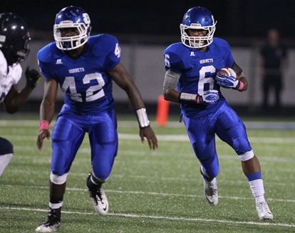 Demaja Price (42) escorts Brendan Young (6) up the field. (Photo by Rick Nation)