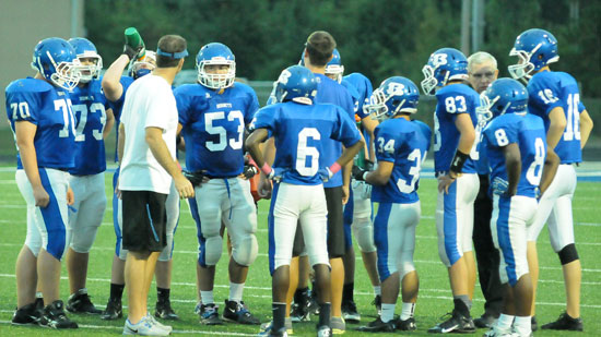 The Bryant sophomore offense huddles with coaches during Monday's game. (Photo by Kevin Nagle)
