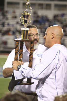 Bryant Blue head coach Dale Jones, right, accepts the Hornet Bowl trophy. (Photo by Rick Nation)