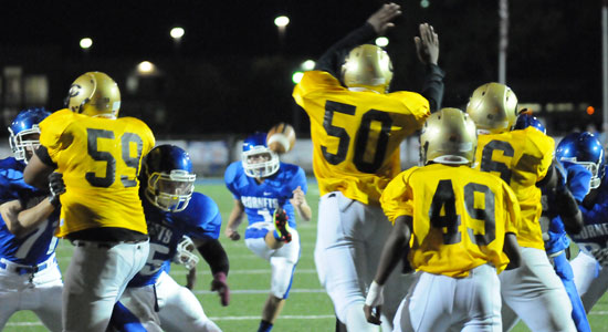 Chase Kincaid kicks an extra point over Central's Terry Humphrey (50). (Photo by Kevin Nagle)