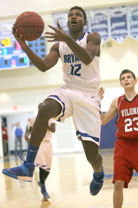 Cedarrian Crosby goes up for a shot as Vilonia's Jacob Fisher trails the play. (Photo by Rick Nation)