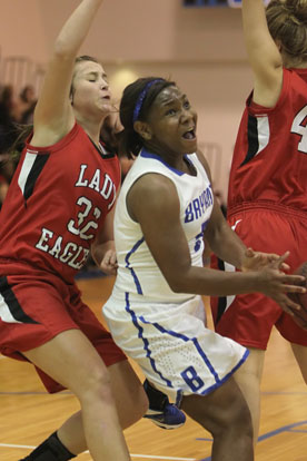 Bryant senior Dezerea Duckworth drives between Vilonia's McKenzie Morris (32) and Kelly Teer (44). (Photo by Rick Nation)