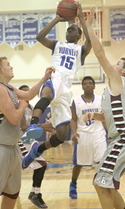 Bryant's Kaleb Turner (15) goes up for a shot in the lane between Benton's Westin Riddick, left, and Brayden Smith. (Photo by Rick Nation)