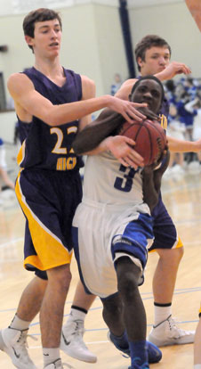 Calvin Allen (3) fights his way to the basket while being fouled by Catholic's John David Falcon (22). (Photo by Kevin Nagle)