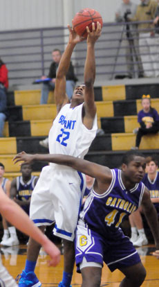 Romen Martin (22) goes high for one of his four offensive rebounds as Catholic's Daniel Nwachuku tries to block out. (Photo by Kevin Nagle)