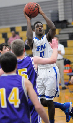 Bryant's Cedarrian Crosby (12) twists to get a shot up over Catholic's William Hancock (5). (Photo by Kevin Nagle)